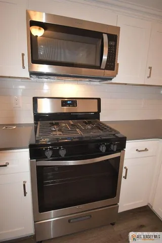 a stove top oven sitting inside of a kitchen
