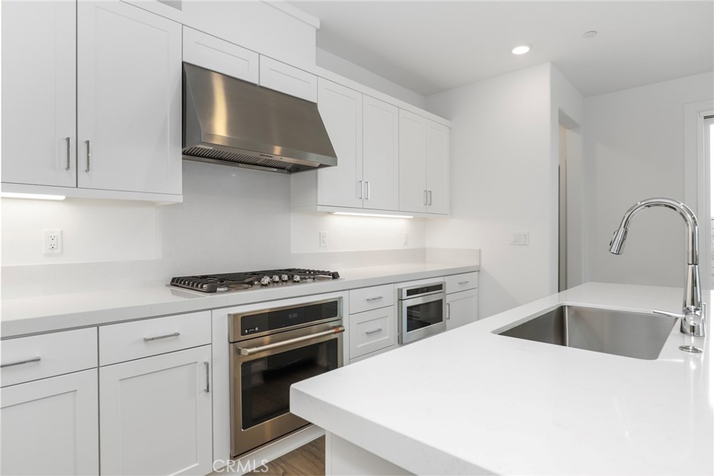 27213 Tamarack Lane Valencia, CA 91381 - Photo 15 of 40 a kitchen with white cabinets stainless steel appliances and sink