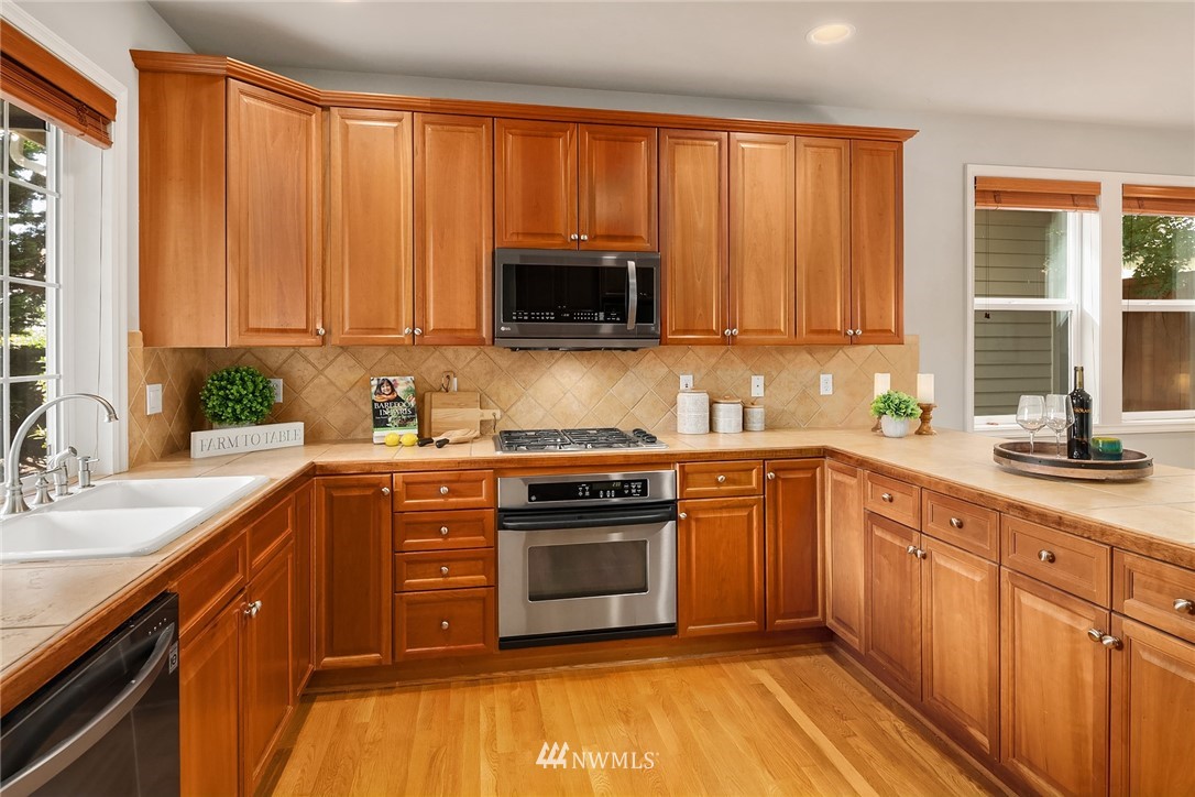 17018 166th Place Southeast Renton, WA 98058 - Photo 5 of 34 a kitchen with wooden cabinets and a sink