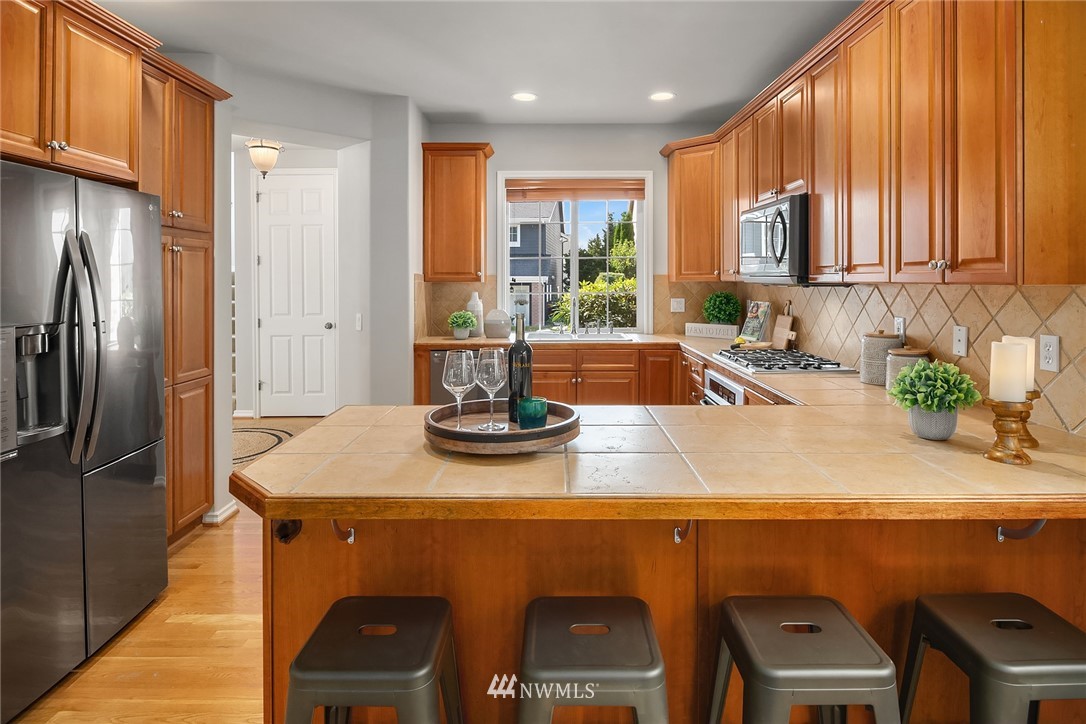17018 166th Place Southeast Renton, WA 98058 - Photo 7 of 34 a kitchen with a sink a refrigerator and cabinets