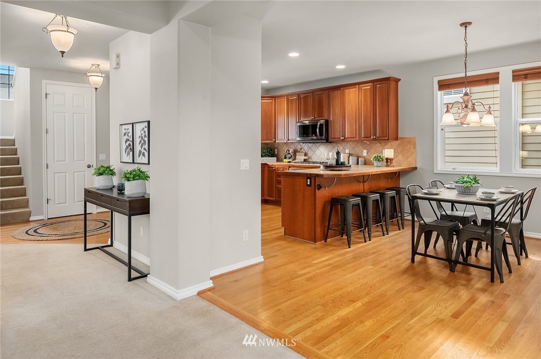 17018 166th Place Southeast Renton, WA 98058 - Photo 10 of 34 a kitchen with stainless steel appliances kitchen island granite countertop a table chairs sink and cabinets