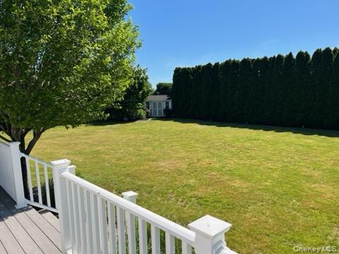 312 Riley Avenue Calverton, NY 11933 - Photo 23 of 30 Spacious backyard featuring a manicured lawn, established privacy hedges, and a functional storage shed