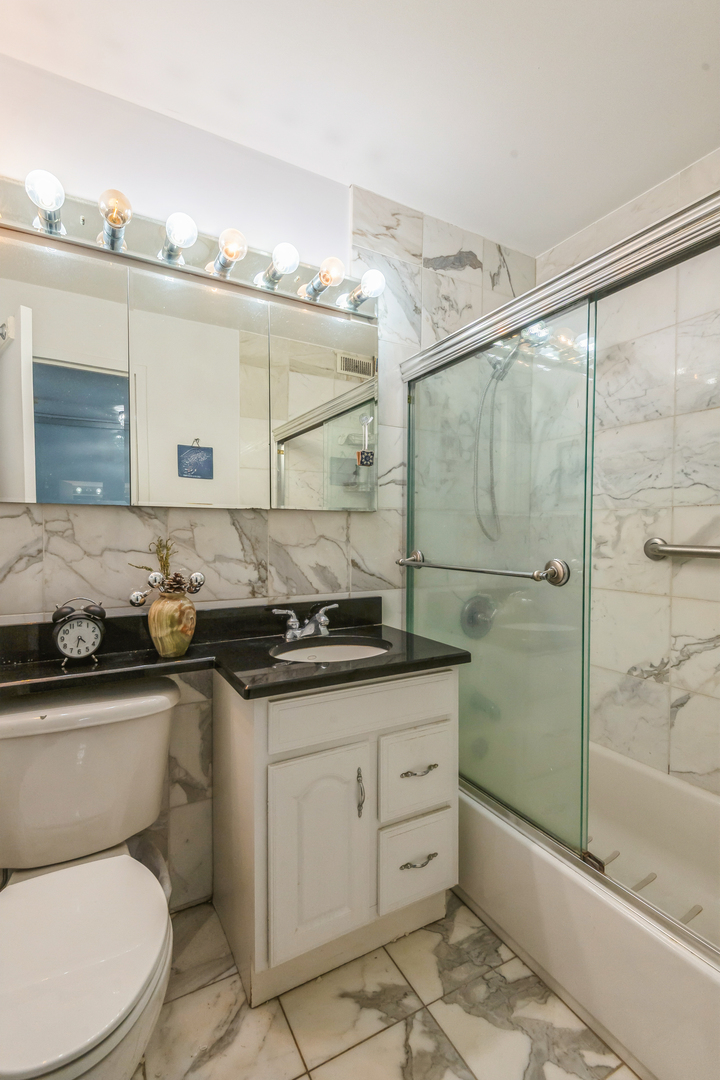 400 East Randolph Street, Unit 1515 Chicago, IL 60601 - Photo 14 of 51 a bathroom with a granite countertop sink a toilet and shower