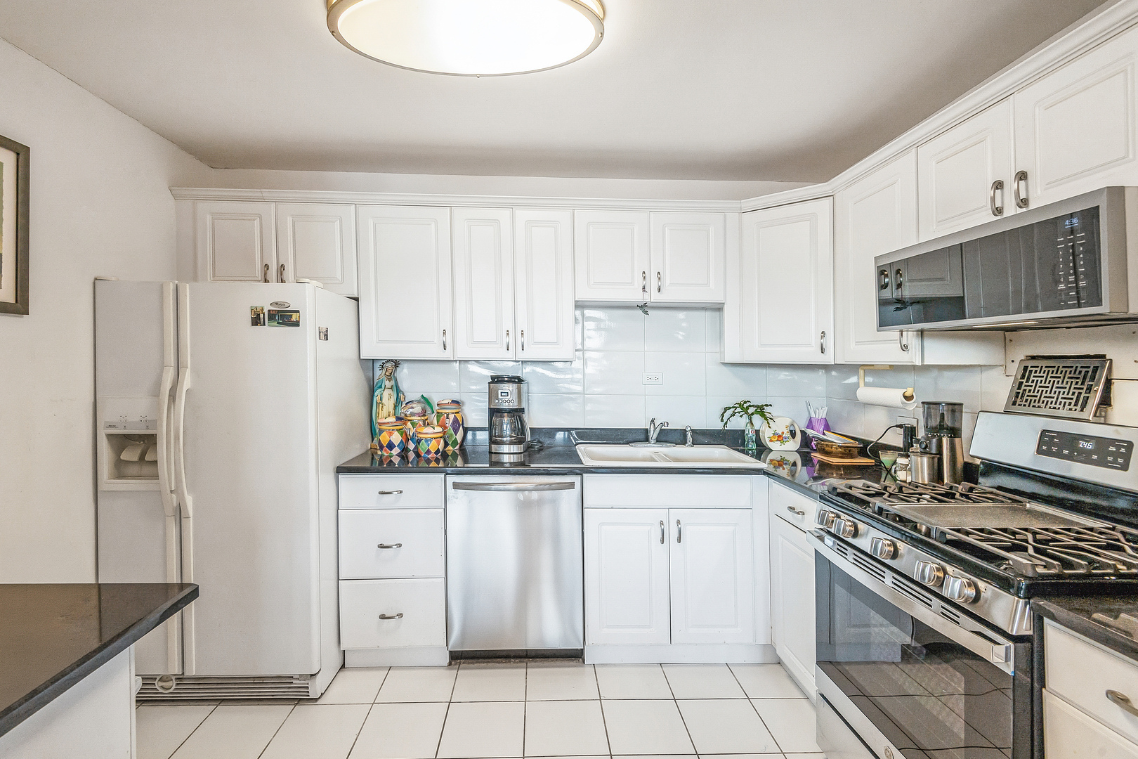400 East Randolph Street, Unit 1515 Chicago, IL 60601 - Photo 10 of 51 a kitchen with stainless steel appliances granite countertop a refrigerator sink and white cabinets