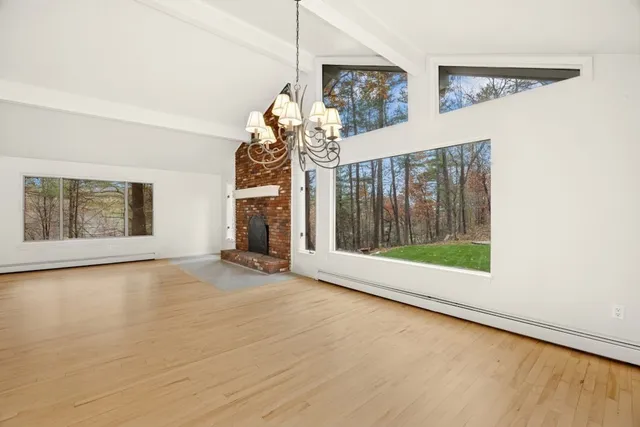 an empty room with wooden floor and fireplace