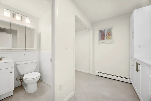 a kitchen with white cabinets and sink