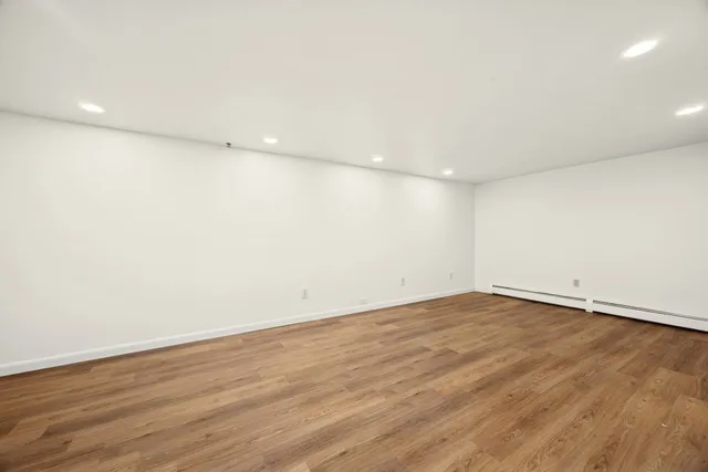 a view of an empty room with wooden floor