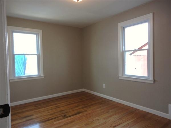 21 Anne Street Springfield, MA 01104 - Photo 21 of 27 an empty room with wooden floor and a window