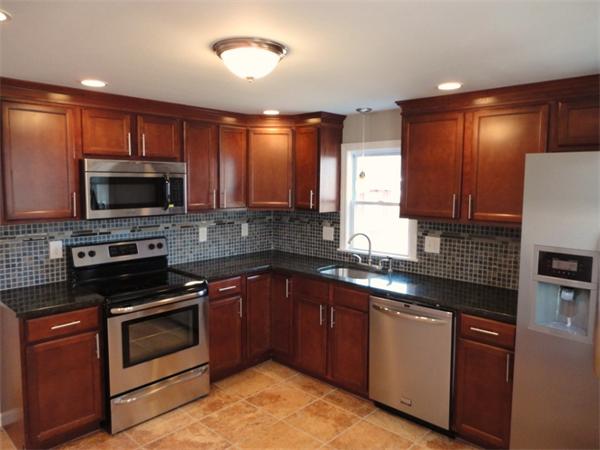 21 Anne Street Springfield, MA 01104 - Photo 26 of 27 a kitchen with granite countertop a stove top oven microwave and cabinets