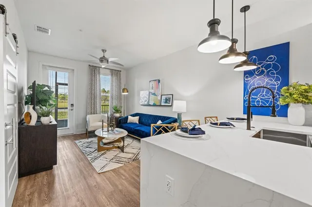 a living room with furniture and a kitchen view
