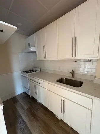 a kitchen with granite countertop white cabinets and white appliances
