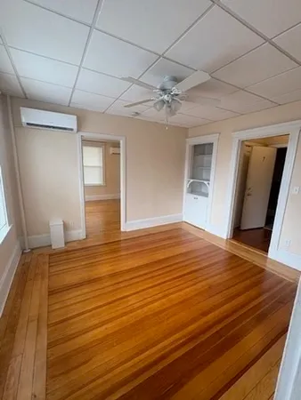 a view of empty room with wooden floor
