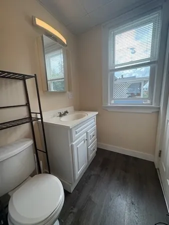 a bathroom with a granite countertop toilet sink and mirror
