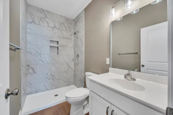 a bathroom with a sink a toilet and shower