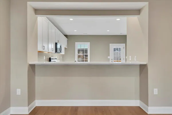 a view of kitchen with cabinets and window