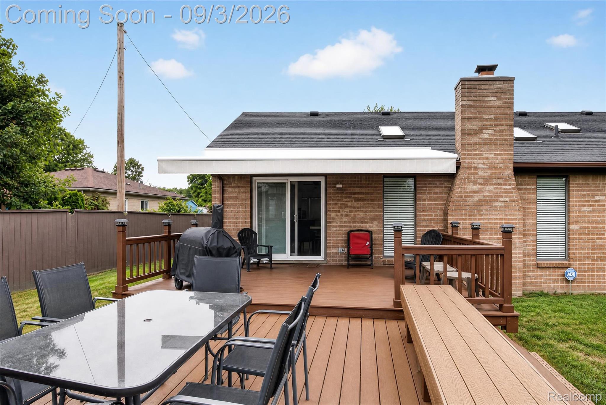 27260 Campbell Road Warren, MI 48093 - Photo 44 of 60 Expansive wood-finish deck with built-in bench seating, dark brown railing, and solar-powered post caps