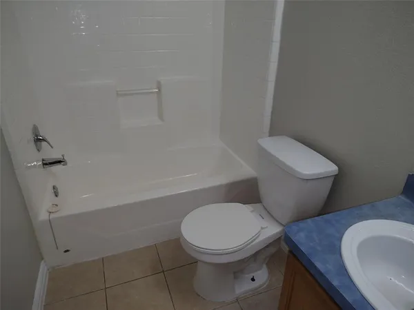 a white toilet sitting next to a bath tub