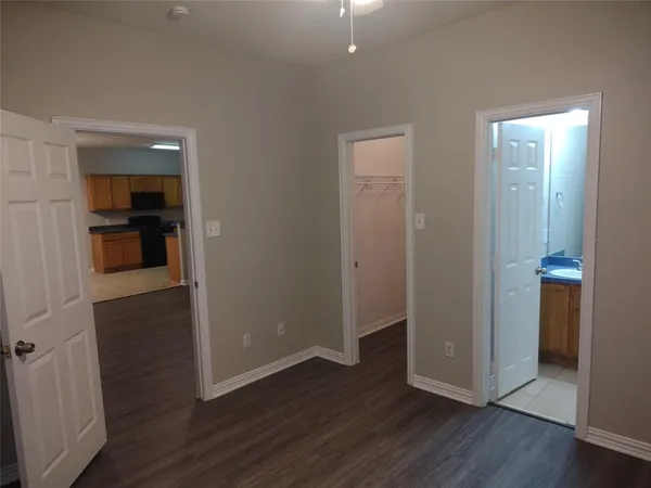 an empty room with wooden floor & closet area