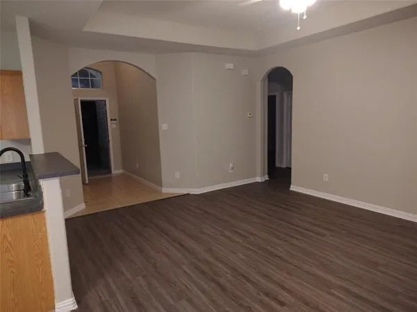 an empty room with wooden floor and mirror