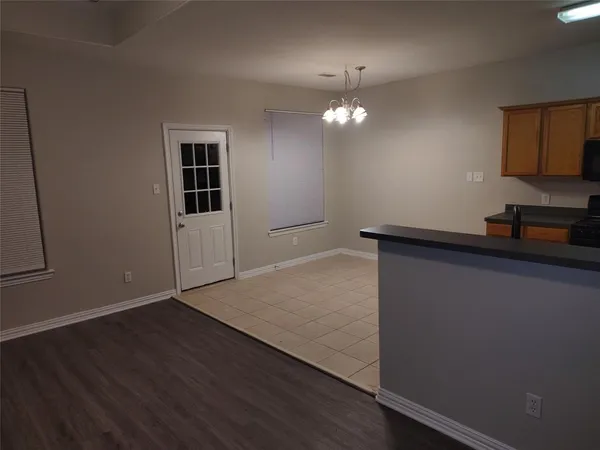 an empty room with wooden floor and cabinet