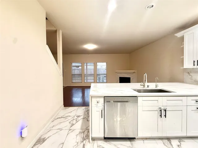 a kitchen with a sink cabinets and wooden floor