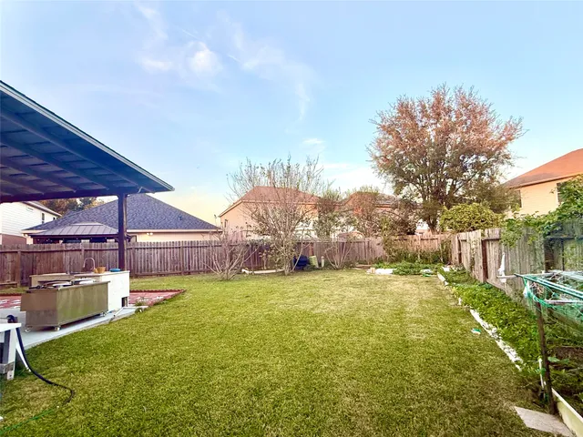 a view of a backyard with table and chairs under an umbrella