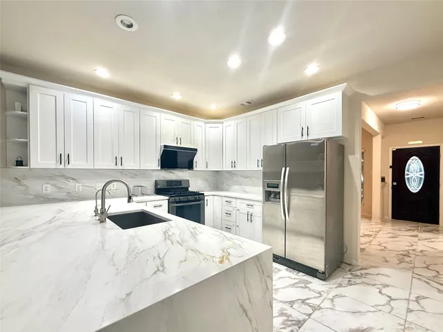 a kitchen with a refrigerator a microwave a sink and a stove