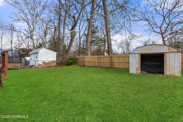 a view of a house with backyard and wooden fence