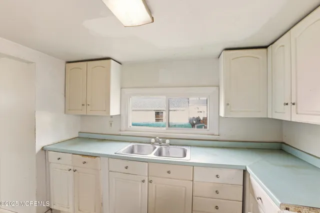 a kitchen with white cabinets and a sink
