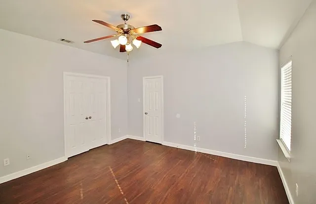 a view of an empty room with wooden floor