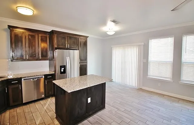 a kitchen with stainless steel appliances granite countertop a sink stove and refrigerator