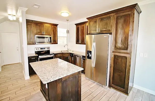 a kitchen with stainless steel appliances granite countertop a refrigerator stove microwave and sink