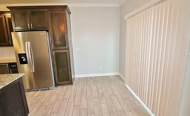 a view of a refrigerator in kitchen and wooden floor