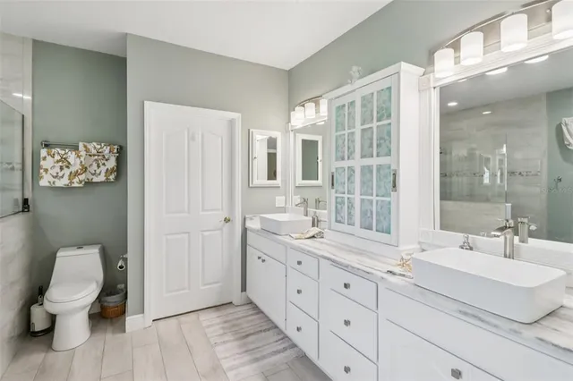 a bathroom with a double vanity sink toilet and a shower