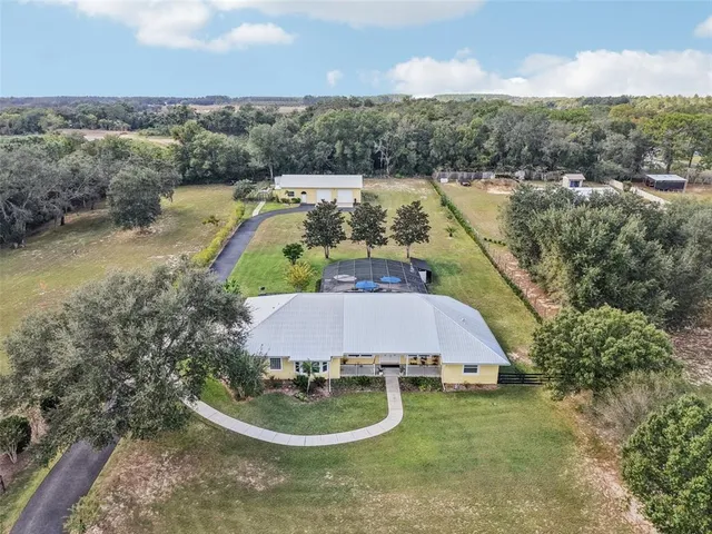 an aerial view of house with yard swimming pool and outdoor seating