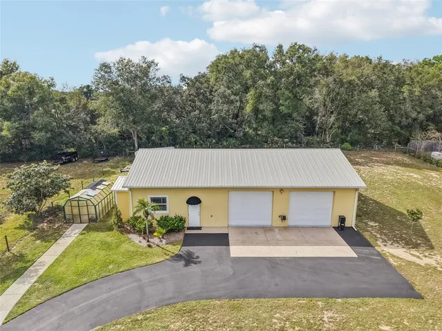 an aerial view of a house with swimming pool and porch