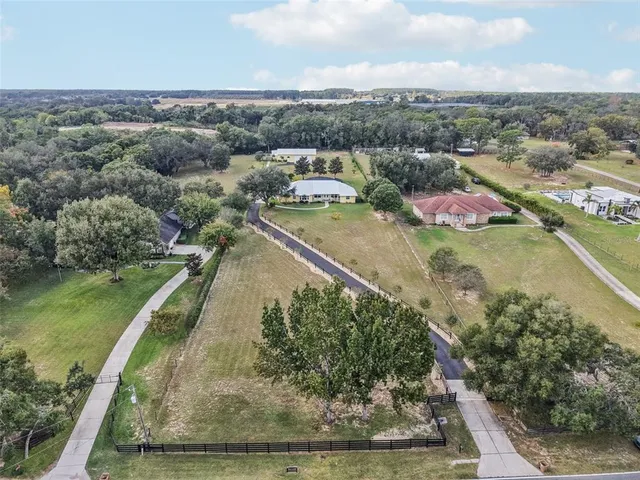 an aerial view of residential houses with outdoor space and ocean view