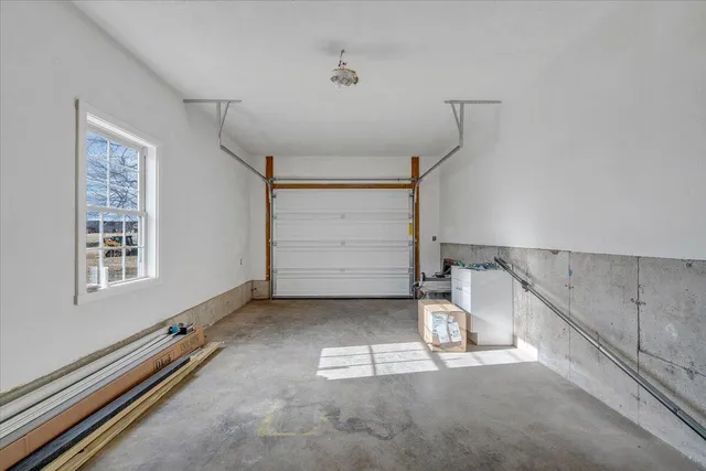 a front view of a house with a yard and large tree