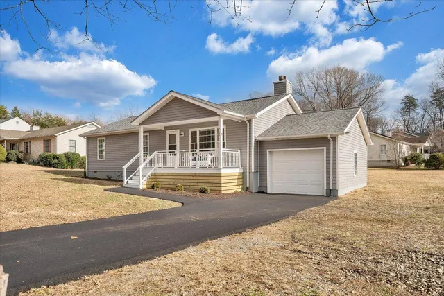 a view of a house with backyard and trees