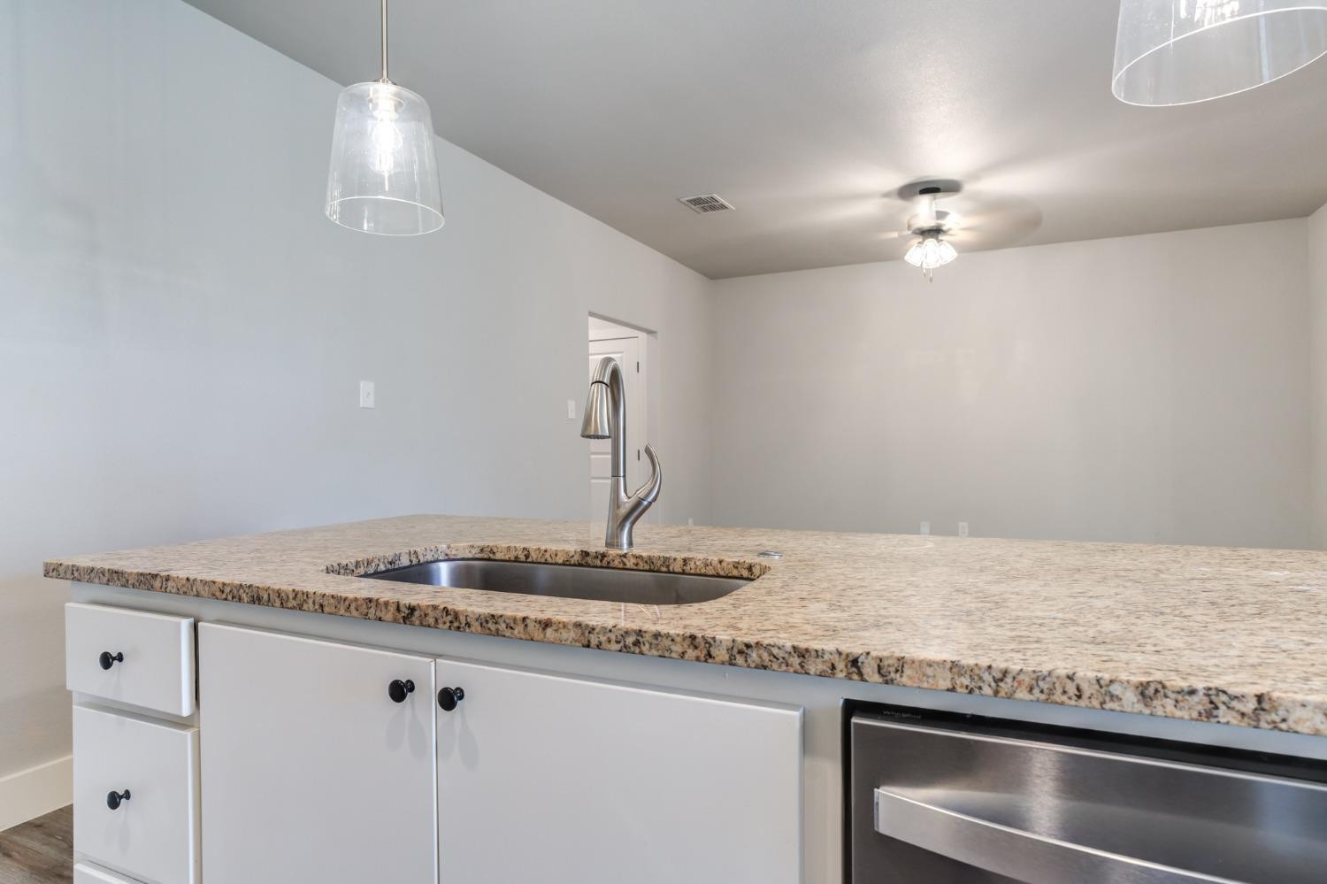 2528 137th Street Lubbock, TX 79423 - Photo 12 of 35 a kitchen with granite countertop a sink stainless steel appliances and a counter space