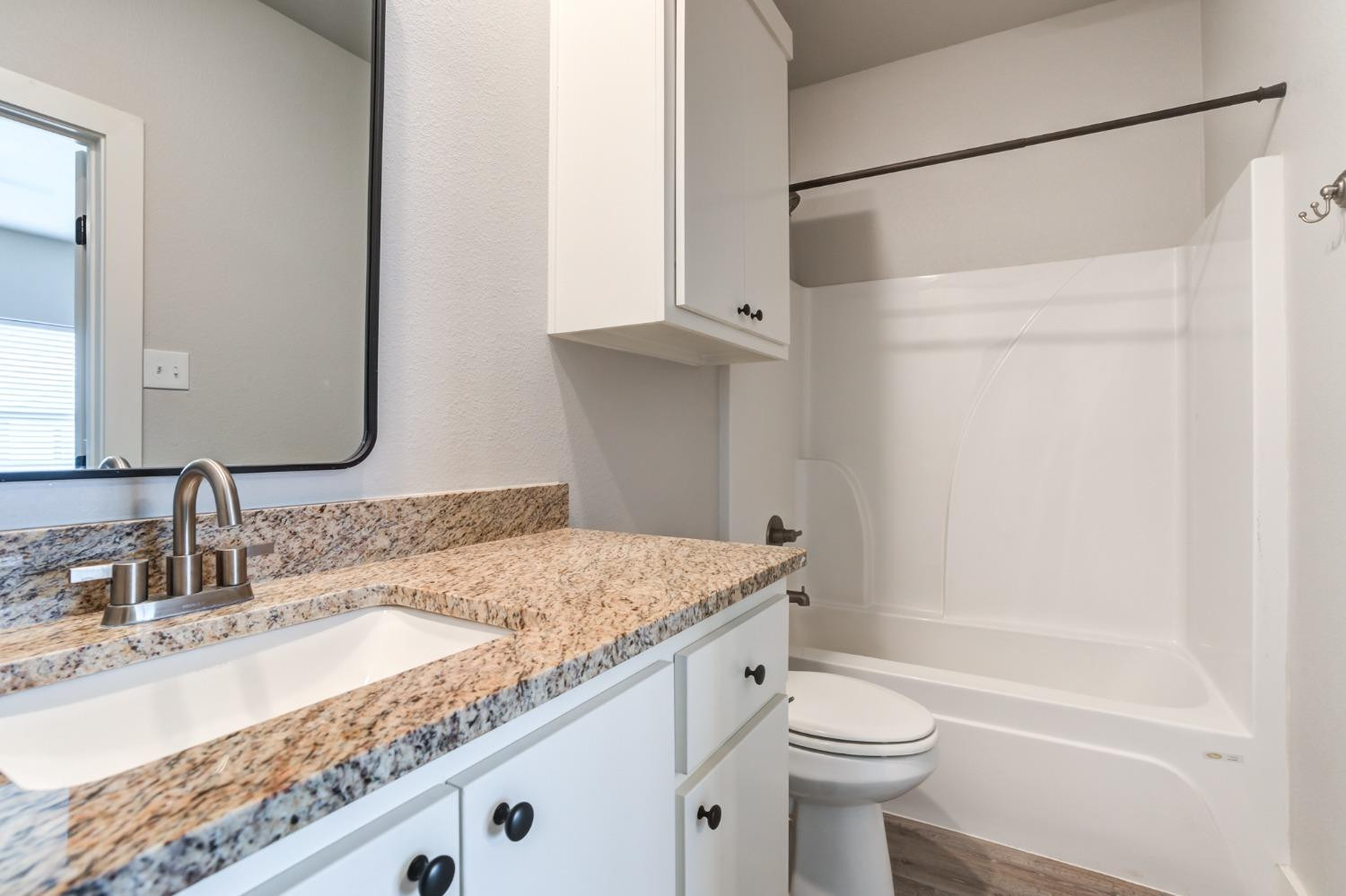 2528 137th Street Lubbock, TX 79423 - Photo 20 of 35 a bathroom with a granite countertop sink a toilet and shower