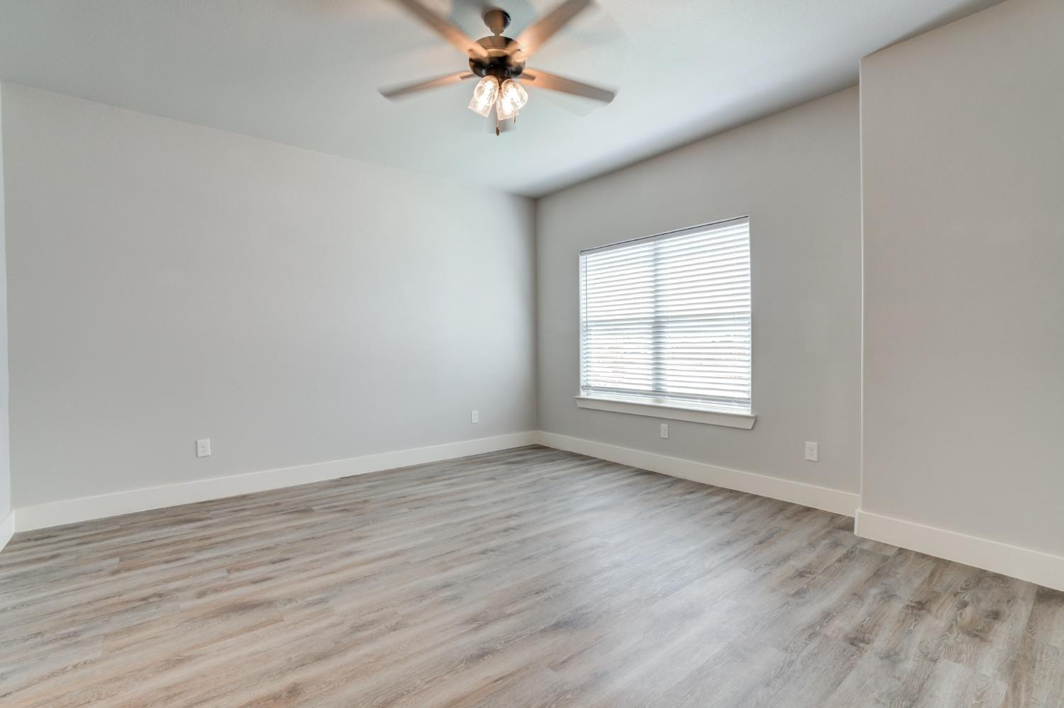 2528 137th Street Lubbock, TX 79423 - Photo 24 of 35 an empty room with wooden floor fan and windows