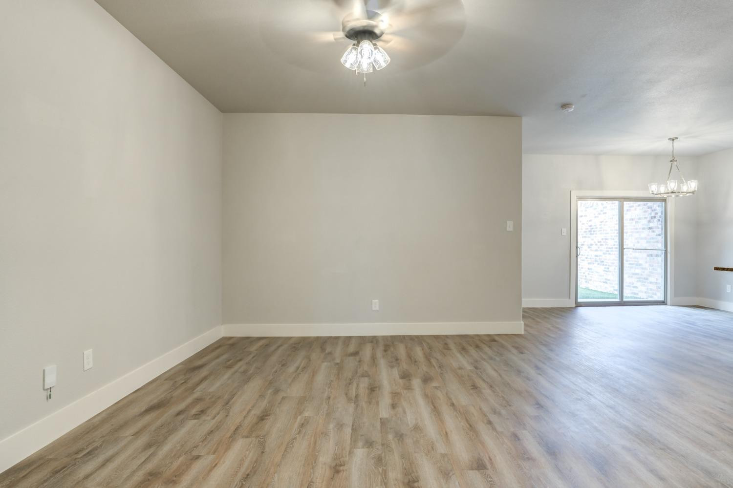 2528 137th Street Lubbock, TX 79423 - Photo 4 of 35 a view of an empty room with wooden floor and a window