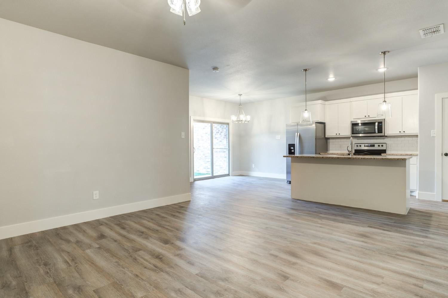 2528 137th Street Lubbock, TX 79423 - Photo 5 of 35 a view of kitchen with kitchen island a sink wooden floor and stainless steel appliances