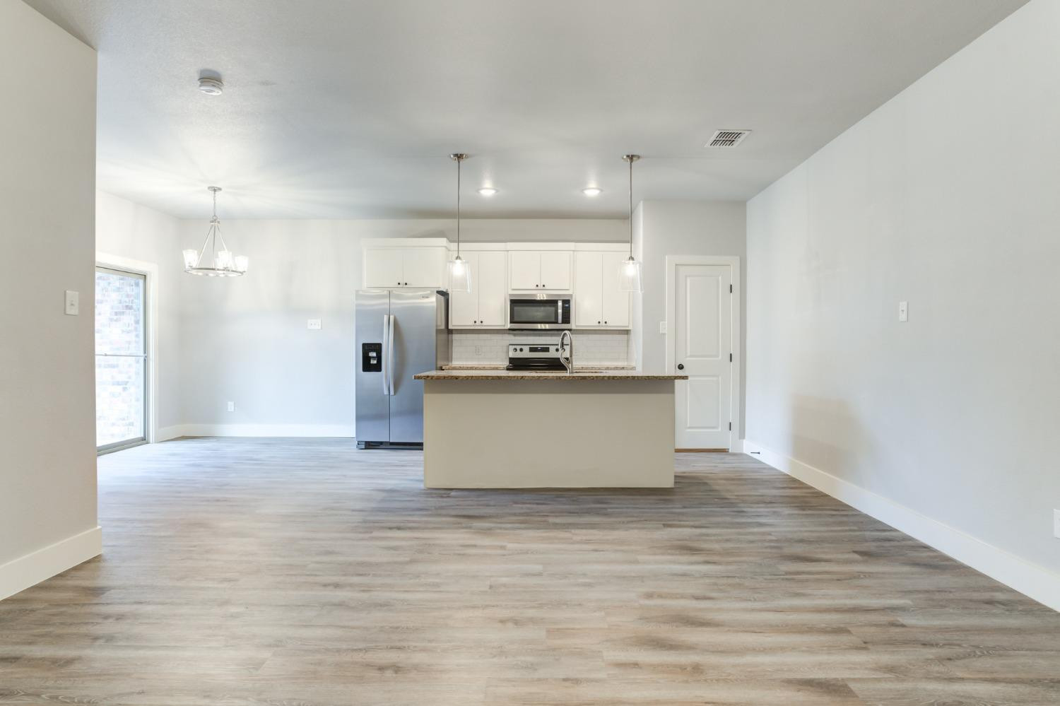 2528 137th Street Lubbock, TX 79423 - Photo 6 of 35 a view of kitchen with kitchen island stainless steel appliances cabinets and wooden floor