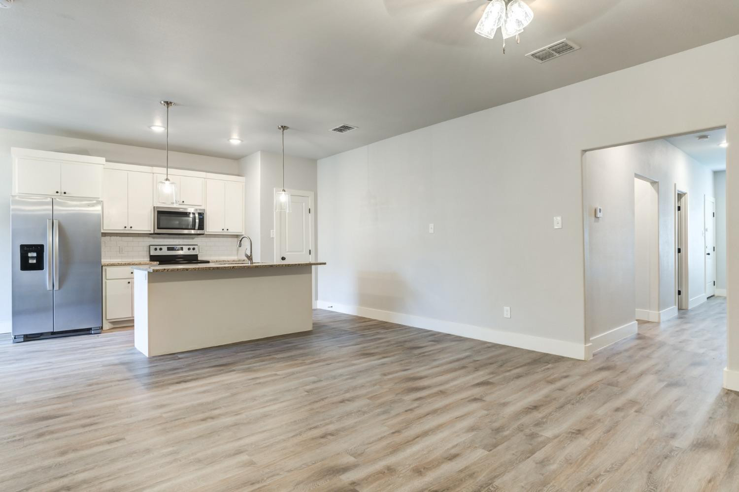 2528 137th Street Lubbock, TX 79423 - Photo 7 of 35 a kitchen with granite countertop a refrigerator and a stove top oven