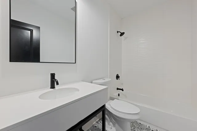 a bathroom with a sink toilet a mirror and shower