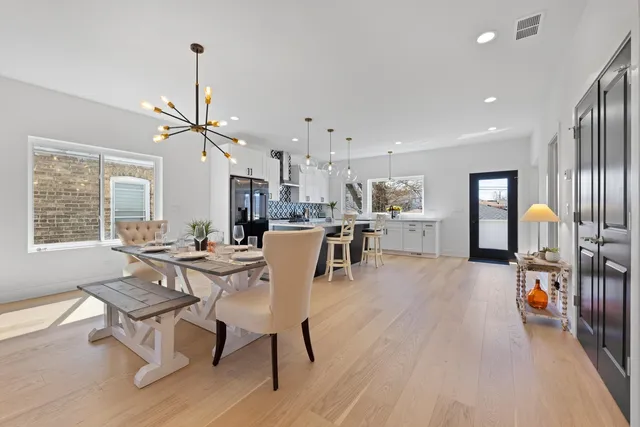 a dining room with furniture a chandelier and wooden floor