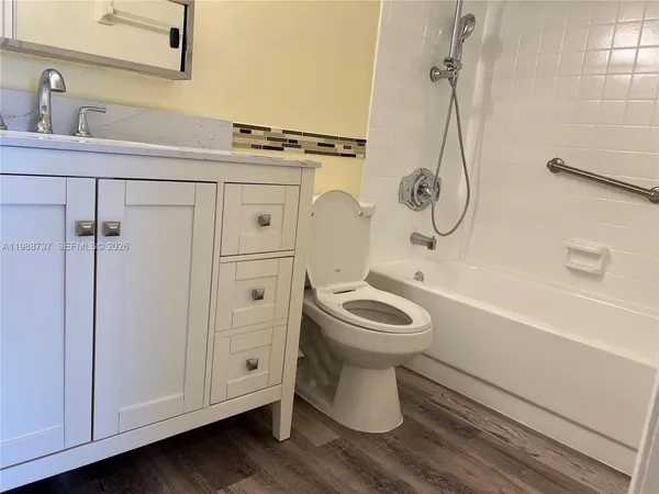 a bathroom with a toilet sink a mirror and shower