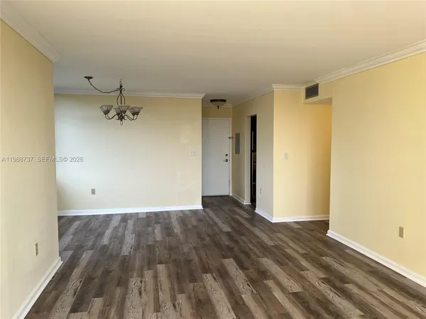 an empty room with wooden floor and a ceiling fan